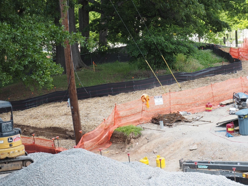 Figure 3. The black silt fence to the back of the picture is supported by metal stakes. In front of the fence is mulch generated from magnolia trees that were removed from the site prior to the beginning of construction.